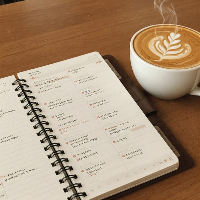 韓国語で予定が書き込まれたおしゃれな手帳とコーヒーカップ